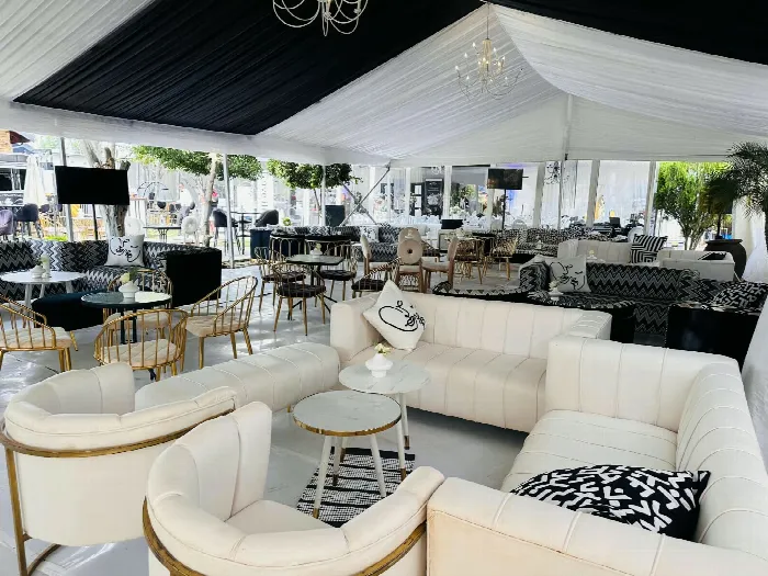 An indoor lounge arranged with white tufted sofas and gold-rimmed chairs