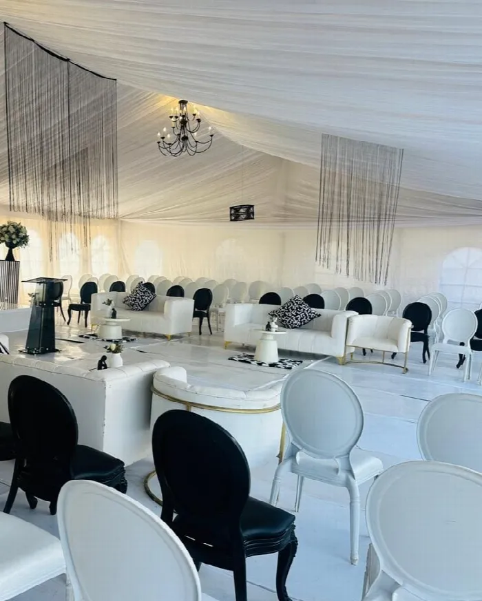 A draped hall dressed in black and white with chandeliers, white sofas and monochrome cushions